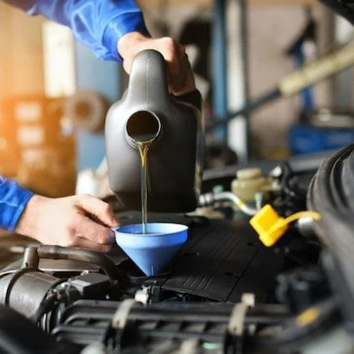 Approved engine oil being topped up through the filler cap of a Volkswagen engine