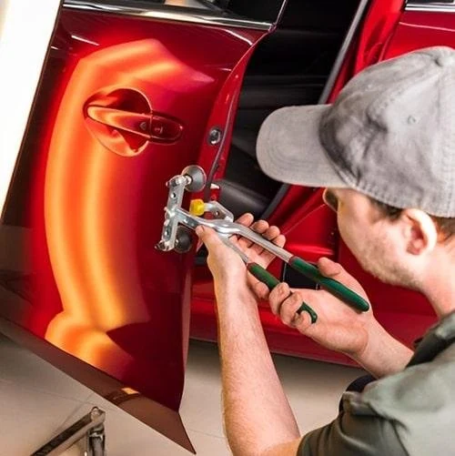Reference view of a technician working on a small door dent