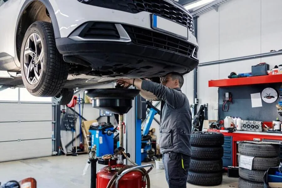 Volkswagen raised on a workshop lift with a technician working underneath